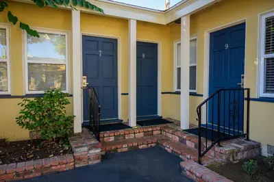 a house with blue doors and a brick walkway at Coronado Inn in San Diego