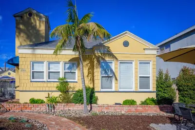 a palm tree in front of a yellow house at Coronado Inn in San Diego