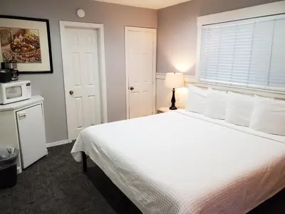 a bedroom with a white bed and a microwave at Coronado Island Inn in San Diego