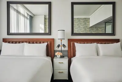 two beds in a hotel room with two mirrors at Pendry San Diego in San Diego