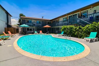 a large swimming pool in a courtyard with chairs at Ramona Valley Inn - Ramona in Ramona