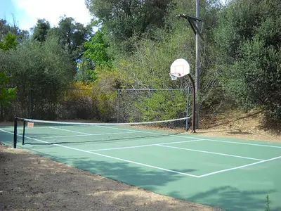 a tennis court with a net and a basketball hoop at Oakzanita Springs Camping Resort Cabin 2 in Descanso