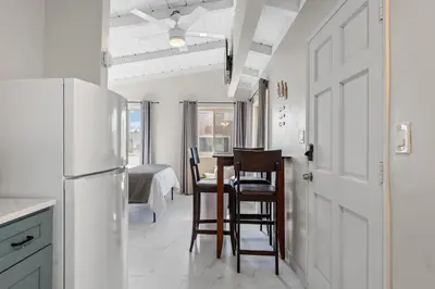a kitchen with a table and chairs and a refrigerator at Sweet Sunset Studio in San Diego
