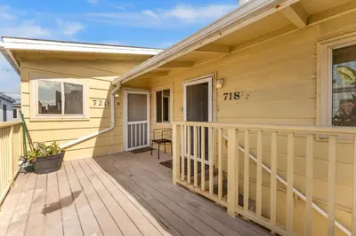 a wooden porch of a yellow house with a deck at Sweet Sunset Studio in San Diego