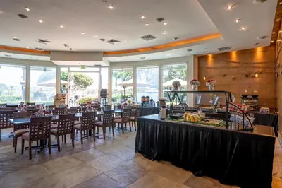 a dining room with tables and chairs and windows at The Dana on Mission Bay in San Diego