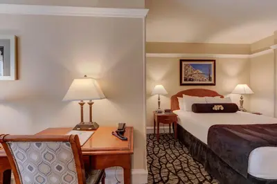 a hotel room with a bed and a desk at Gaslamp Plaza Suites in San Diego