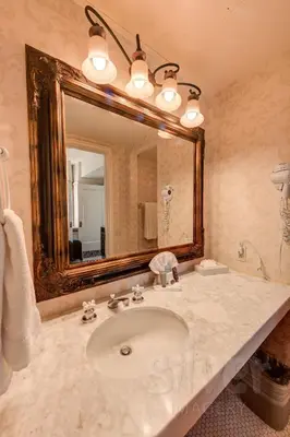 a bathroom with a sink and a large mirror at Gaslamp Plaza Suites in San Diego