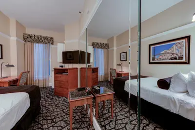 a hotel room with two beds and a television at Gaslamp Plaza Suites in San Diego