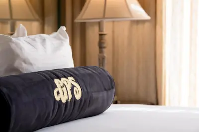 a rolled up towel on a bed with a lamp at Gaslamp Plaza Suites in San Diego