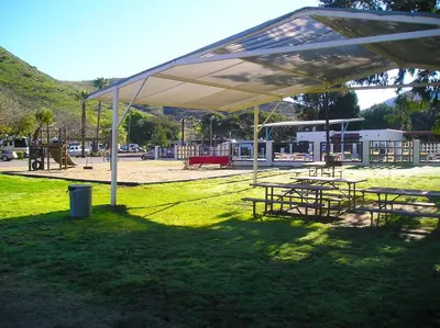 a group of picnic tables under a canopy in a park at Pio Pico Camping Resort Studio Cabin 7 in Jamul