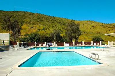 a swimming pool with a mountain in the background at Pio Pico Camping Resort Studio Cabin 7 in Jamul