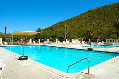 a large swimming pool with a mountain in the background at Pio Pico Camping Resort Two-Bedroom Cabin 12 in Jamul