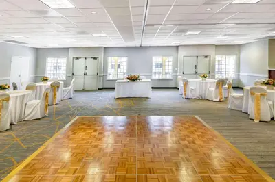 a banquet hall with white tables and white chairs at Wyndham Garden San Diego in San Diego
