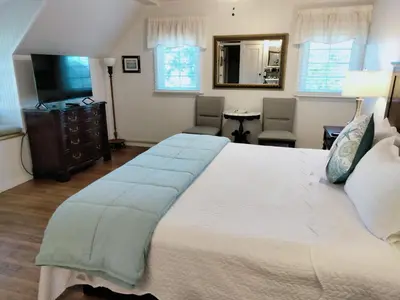 a bedroom with a large white bed and a television at Cherokee Lodge in San Diego