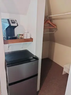 a refrigerator in a small kitchen with a shelf at Cherokee Lodge in San Diego