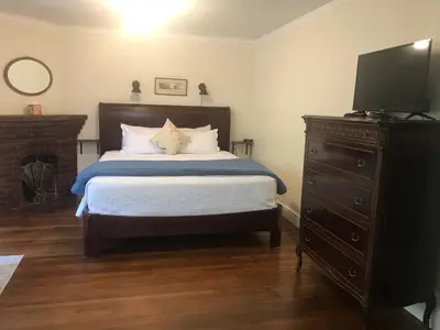 a bedroom with a bed and a dresser with a television at Cherokee Lodge in San Diego