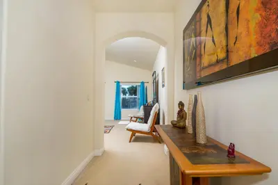 a living room with a table and a painting on the wall at Holiday Home in Oceanside