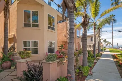 a house with palm trees and a sidewalk at Holiday Home in Oceanside