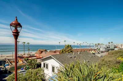 a street light next to a white house and a beach at Holiday Home in Oceanside
