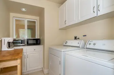 a white laundry room with a washer and dryer at Holiday Home in Oceanside