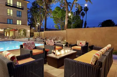 a patio with chairs and tables and a pool at Hilton Garden Inn San Diego Old Town/Sea World Area in San Diego