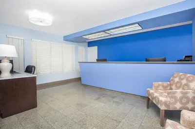 a waiting room with a blue wall and a chair at Baymont by Wyndham San Diego Downtown in San Diego