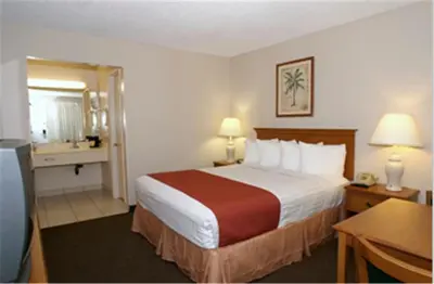 a hotel room with a large bed and a bathroom at Pleasant Inn in San Diego