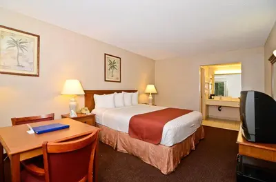 a hotel room with a bed and a desk and a television at Pleasant Inn in San Diego