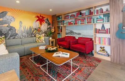 a living room with a couch and two red chairs at The Wayfarer San Diego in San Diego