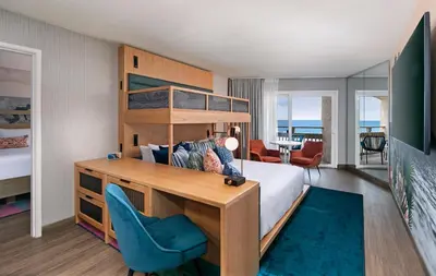 a bedroom with a bunk bed and a blue chair at The Wayfarer San Diego in San Diego