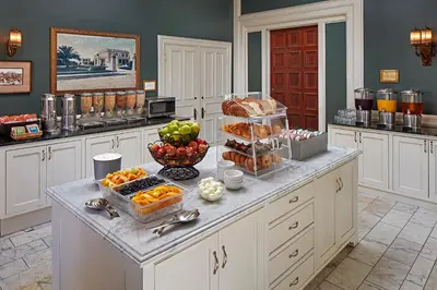 a kitchen with a counter with fruits and pastries on it at Glorietta Bay Inn in San Diego