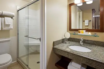 a bathroom with a sink and a toilet and a mirror at Glorietta Bay Inn in San Diego