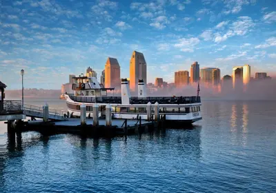 a boat docked at a dock in the water with a city at Glorietta Bay Inn in San Diego