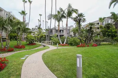 a walkway through a park with palm trees at North Coast Village Retreat B111 in Oceanside