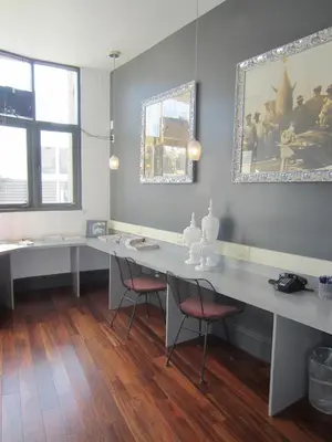 a room with two desks with chairs and a painting on the wall at La Pensione Hotel in San Diego