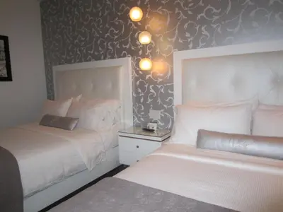 a bedroom with two beds and a wall with patterns at La Pensione Hotel in San Diego