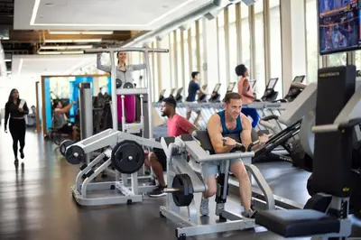 two men sitting on gym machines in a gym at The Westgate Hotel in San Diego