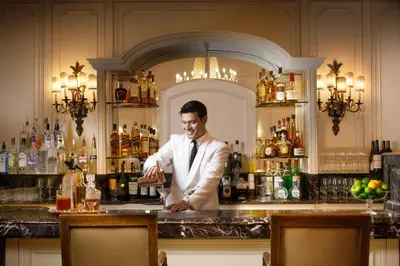 a man in a suit standing at a bar at The Westgate Hotel in San Diego