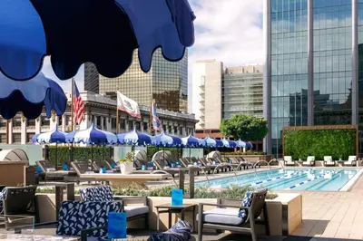 a pool with chairs and umbrellas in front of a building at The Westgate Hotel in San Diego
