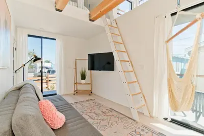 a living room with a couch and a tv at Modern Beach Home Steps To The Sand in San Diego