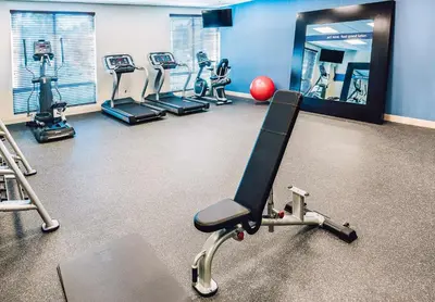 a gym with several tread machines and a mirror at Hampton Inn & Suites by Hilton Mission Viejo Laguna San Juan Capistrano in Mission Viejo