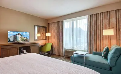 a hotel room with a bed and a desk and a television at Hampton Inn & Suites by Hilton Mission Viejo Laguna San Juan Capistrano in Mission Viejo