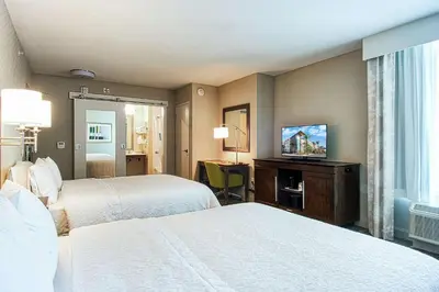 a hotel room with two beds and a flat screen tv at Hampton Inn & Suites by Hilton Mission Viejo Laguna San Juan Capistrano in Mission Viejo