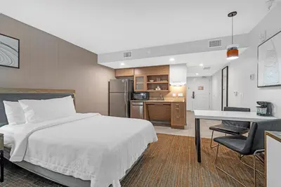 a bedroom with a bed and a desk and a kitchen at Homewood Suites By Hilton San Diego Central in San Diego