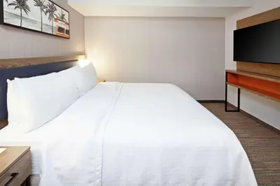 a hotel room with a large bed and a flat screen tv at Homewood Suites By Hilton San Diego Central in San Diego