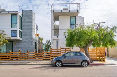 a small car parked next to a tree in front of a building at Steps to the Beach, Rooftop Deck in San Diego