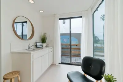 a bathroom with a sink and a chair and a mirror at Steps to the Beach, Rooftop Deck in San Diego