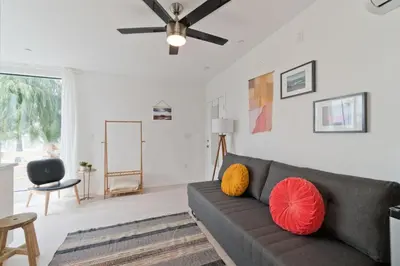 a living room with a couch and a ceiling fan at Steps to the Beach, Rooftop Deck in San Diego