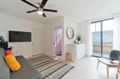 a living room with a couch and a ceiling fan at Steps to the Beach, Rooftop Deck in San Diego