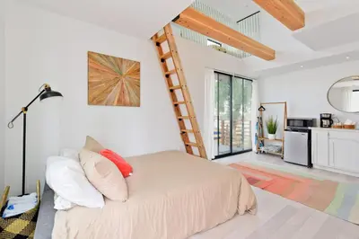 a bedroom with a bed and a ladder at New Beach House, Steps to Sand in San Diego